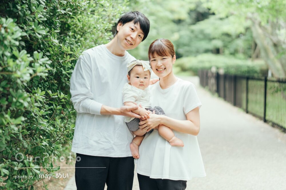 輝く緑を背景にカジュアルな家族写真