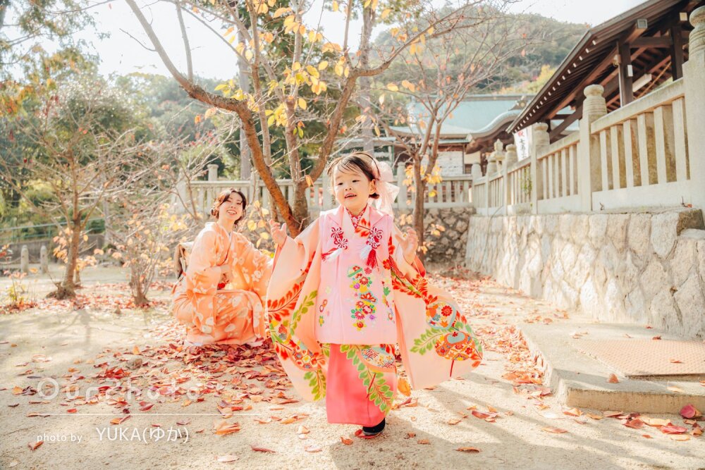 「楽しそうに撮影」紅葉美しい神社で和装の愛らしい女の子の七五三撮影
