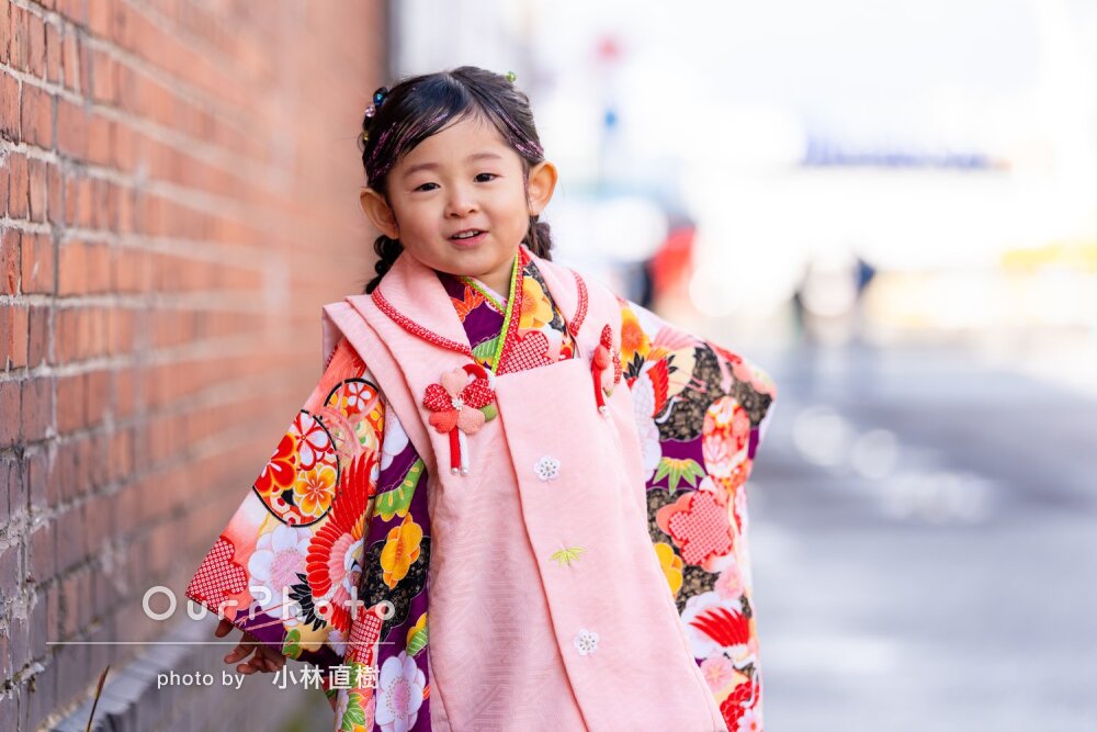 愛くるしい表情の女の子！鮮やかな和装が映える街中で七五三の撮影