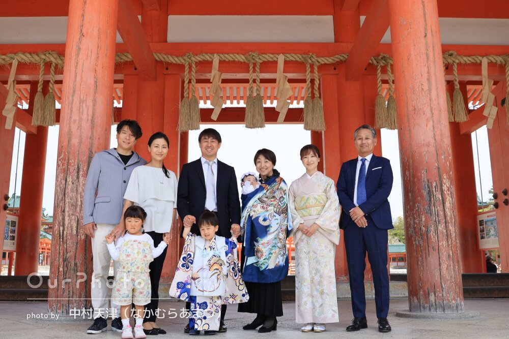 朱色の社殿を背景に産着が映える！親戚一同で和やかなお宮参りの撮影