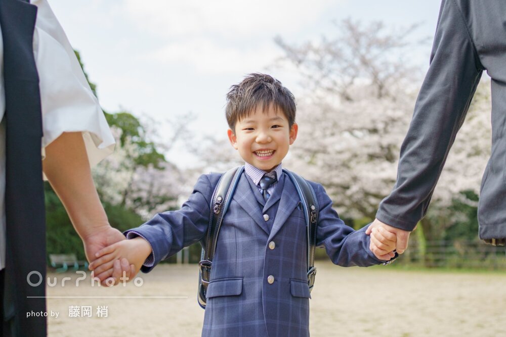 「自然と柔らかな表情」桜咲く公園で笑顔！ランドセルと入学記念の撮影