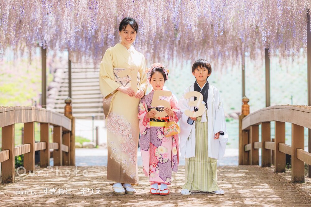 「子供たちもリラックス」藤棚を背景に3人の和装が映える七五三の撮影